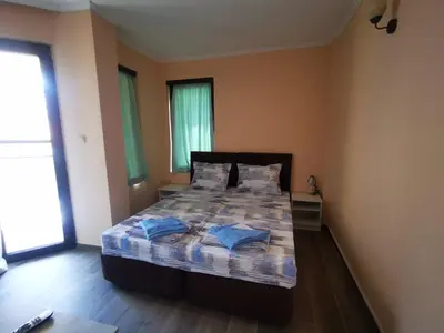 a bedroom with a bed with blue pillows on it at Къща за гости DOSH in Sozopol