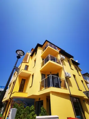 a yellow building with a blue sky in the background at Къща за гости DOSH in Sozopol