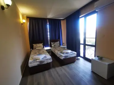 a room with two beds and a large window at Къща за гости DOSH in Sozopol