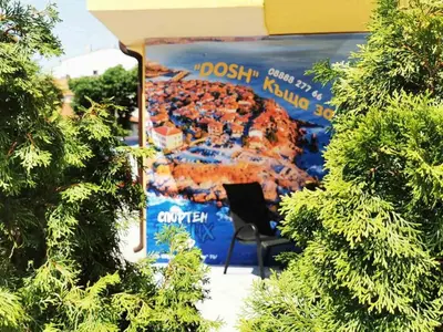 a sign for a bus stop with a table and a chair at Къща за гости DOSH in Sozopol