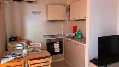 a small kitchen with a table and a small kitchen with a stove at 1BD Apartment in Royal Sun Complex, Sunny Beach by Flat Mаnager in Sunny Beach