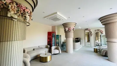 a living room with columns and couches and flowers at JADORE Secret Garden Panoramic Studio in Sunny Beach