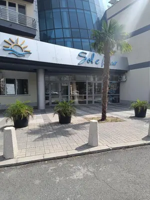a building with a palm tree in front of it at Sol e Mar Sunny Beach in Sunny Beach