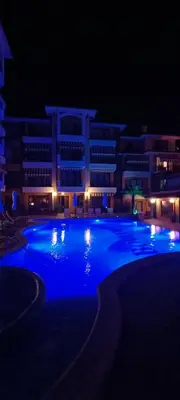 a large swimming pool with blue lights in front of a building at Boulevard Sea Residenz in Sunny Beach