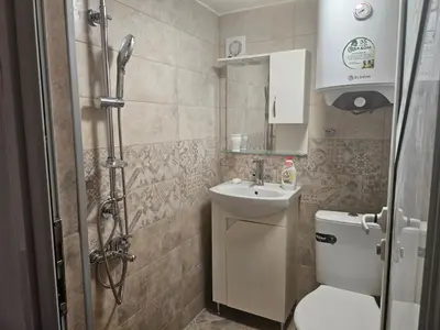 a bathroom with a toilet and a sink and a shower at Гарсониера в центъра на град Бургас in Burgas City