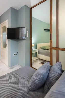 a bedroom with a large mirror and a bed with a television at Dany's Apartments in Varna City