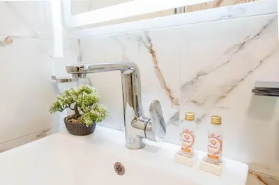 a bathroom sink with a faucet and two bottles of soap at Dany's Apartments in Varna City