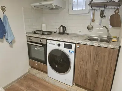 a kitchen with a washing machine and a sink at Гарсониера в центъра на град Бургас in Burgas City