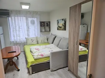 a small room with a bed and a mirror at Гарсониера в центъра на град Бургас l in Burgas City