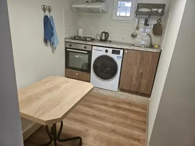 a kitchen with a washing machine and a table at Гарсониера в центъра на град Бургас l in Burgas City