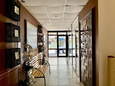 a hallway with two chairs and a door to a building at Emerald Paradise - Menada Apartments in Sunny Beach