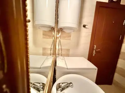 a mirror in a bathroom with two sinks and a toilet at Emerald Paradise - Menada Apartments in Sunny Beach