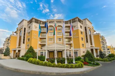 a large yellow building with flags in front of it at 2-Bedroom Apartment in Villa Florence Boutique ApartHotel in Sveti Vlas