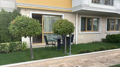 a house with a table and a chair in the yard at 2-Bedroom Apartment in Villa Florence Boutique ApartHotel in Sveti Vlas