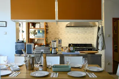 a kitchen with a table with plates and wine glasses at Luxury, private pool, sauna, beach! in Banya