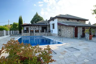 a villa with a swimming pool in front of a house at Luxury, private pool, sauna, beach! in Banya