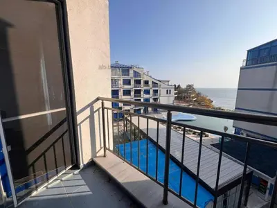 a balcony with a view of the ocean and a pool at Двустаен апартамент с морска панорама в Blue Bay Palace in Pomorie