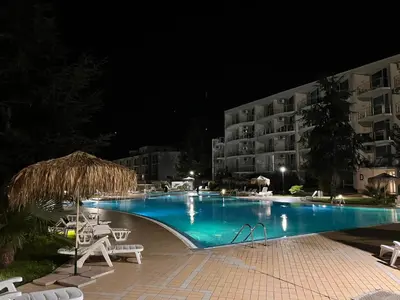 a swimming pool in front of a hotel at night at Sarafovo ATLANTIS 58 in Burgas City