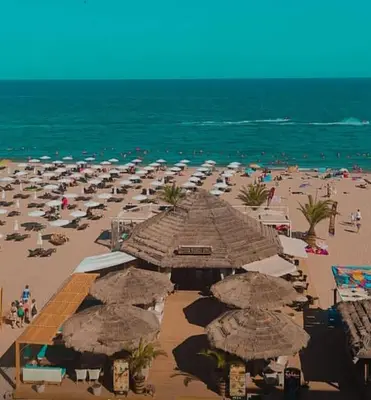 a beach with a lot of umbrellas and the ocean at Seafront Luxury Studio with Panoramic Sea View, Sunny Beach in Sunny Beach