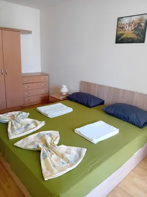a bedroom with a green bed with towels on it at Двустаен апартамент във Виго Панорама Несебър in Nesebar