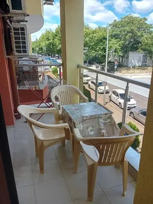 a table and chairs on a balcony with a view of a street at Двустаен апартамент във Виго Панорама Несебър in Nesebar