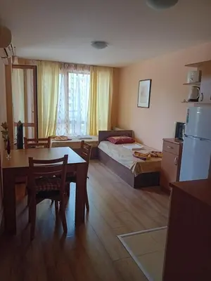 a room with a bed and a table and a bed and a kitchen at Двустаен апартамент във Виго Панорама Несебър in Nesebar