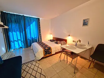 a bedroom with a bed and a table and a window at complex Rose Residence Studio in Sunny Beach