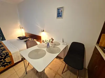 a bedroom with a white table with two chairs and a bed at complex Rose Residence Studio in Sunny Beach