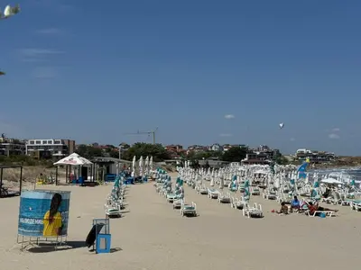 a beach with many chairs and people sitting on it at Apartment Victoria in Kraymorie