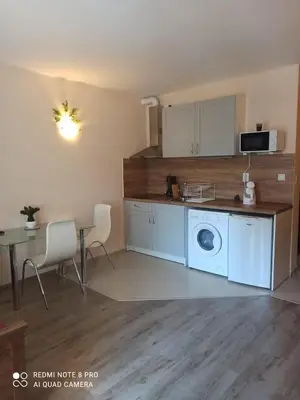 a kitchen with a washing machine and a table at Amber Beach in Sunny Beach