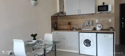 a kitchen with a washing machine and a table with chairs at Amber Beach in Sunny Beach