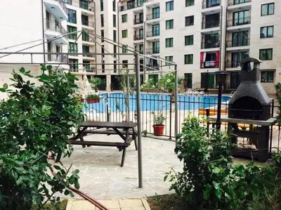 a patio with a table and a grill and buildings at Amber Beach in Sunny Beach
