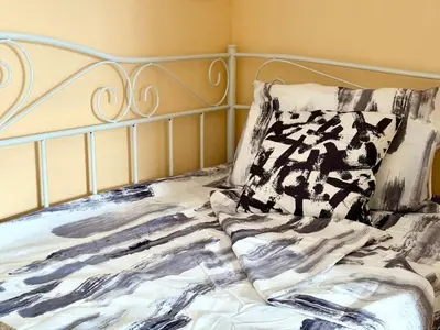 a bed with a black and white comforter and a pillow at Varna Thermae Loft in Varna City