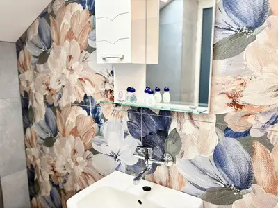 a bathroom with a sink and a flower wallpaper at Varna Thermae Loft in Varna City