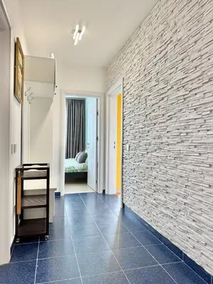 a room with a brick wall and a hallway at SeaSky SmartHome-Penthouse with private Parking in Burgas City
