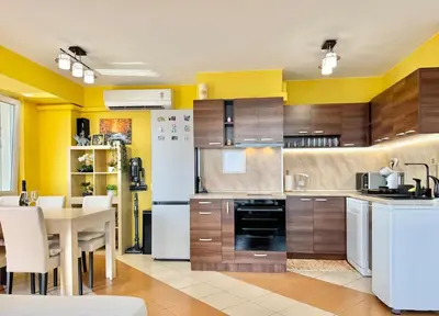 a kitchen with wooden cabinets and a white refrigerator at SeaSky SmartHome-Penthouse with private Parking in Burgas City