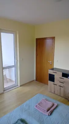 an empty room with a bed and a window at Apartment Photinia in Byala