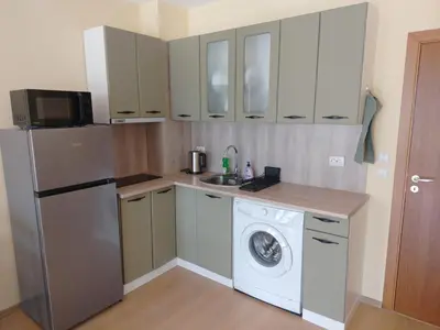 a kitchen with a refrigerator and a washing machine at Apartment Photinia in Byala