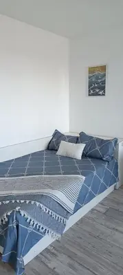 a bed with a blue comforter in a bedroom at Wild lakes home in Burgas City
