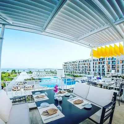 a patio with a table and chairs on a balcony at Apartment on the Beach in Sveti Vlas
