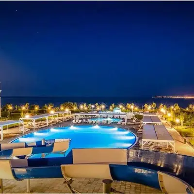 a large swimming pool at a resort at night at Apartment on the Beach in Sveti Vlas