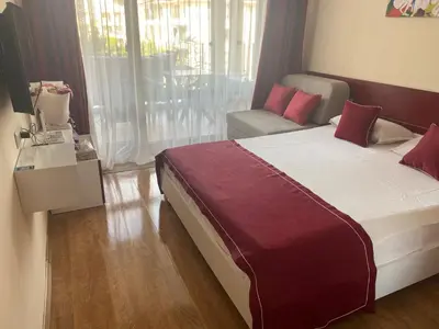 a hotel room with a bed and a couch at Apartment on the Beach in Sveti Vlas