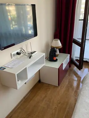 a white cabinet with a television on a wall at Apartment on the Beach in Sveti Vlas