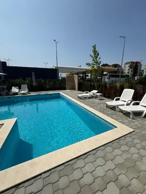 a swimming pool with lounge chairs next to a building at Студия Магнолия 6, Солнечный берег Болгария in Sunny Beach