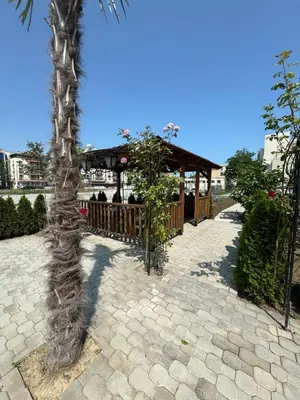 a palm tree in a patio with a gazebo at Студия Магнолия 6, Солнечный берег Болгария in Sunny Beach