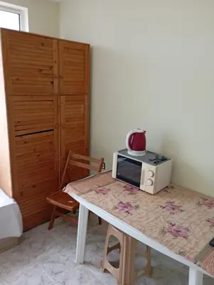 a kitchen with a table with a microwave on it at Апартамент планина in Varna City