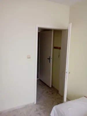 an empty room with a bed and a closet at Апартамент планина in Varna City