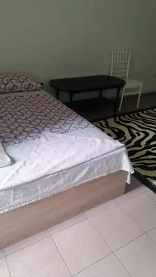 a bed with a table and a chair in a room at Апартамент център in Varna City