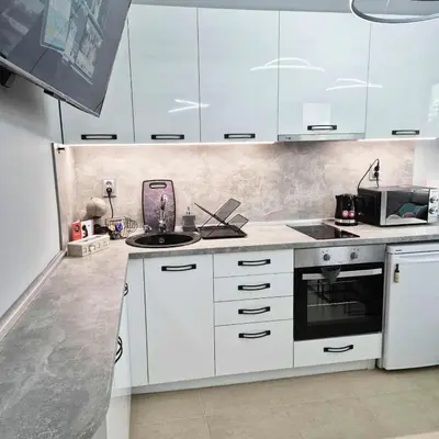 a white kitchen with white cabinets and a sink at Paradise in Burgas City