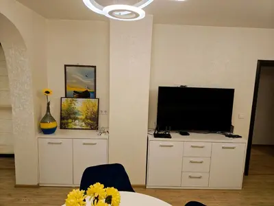a living room with a television and a table with flowers at Trend Apart in Burgas City